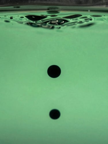 Sleek macro photography of physical black ink droplets dispersing in clear water, high-contrast cool studio lighting, sharp registration lines