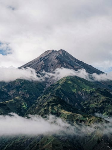 Misty Andean landscape with the Cotopaxi volcano peak emerging from clouds, cool overcast mountain light, high contrast, 35mm