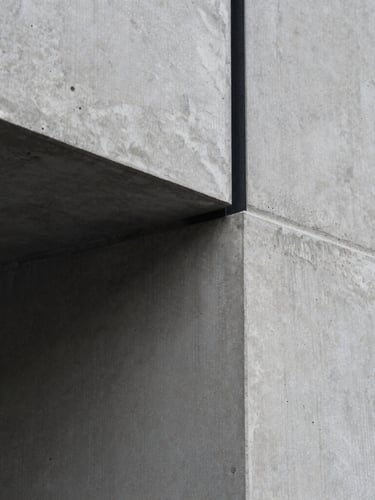 Extreme close-up of a flawless concrete pour meeting a black steel beam, sharp morning light, desaturated charcoal tones, minimalist architectural photography, 35mm