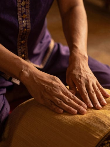 Close-up of skilled hands performing traditional Thai stretching on a client, warm low-key golden-hour lighting, shallow depth of field, 35mm