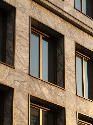 Close-up architectural detail of premium marble facade and brass window frame of a corporate building, golden hour light, high contrast