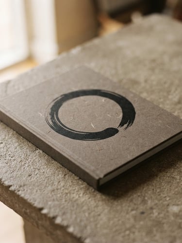 A clean tactile book cover of 'Align' by Richard Muralee, resting on a warm stone-gray textured table under soft directional window light, shallow depth of field, 35mm