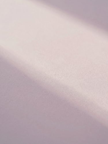 Abstract light play on textured paper, soft diffused morning light, pale pastel tones, shallow depth of field, 35mm