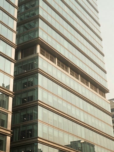 An elegant architectural detail of a modern financial district in Mumbai, clean geometric glass lines reflecting bright morning sunlight, soft corporate green tones