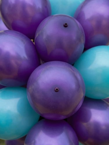 Macro shot of high-quality metallic and matte balloon textures in purple and turquoise, showcasing rich colors and professional finish