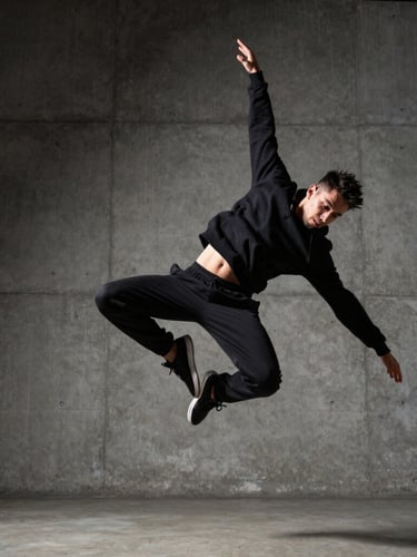 Dynamic low-angle shot of a street dancer frozen mid-air, high contrast lighting, concrete background, sharp focus on movement