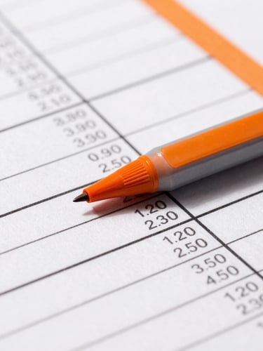 Macro crop of a printed financial spreadsheet with sharp directional shadows, stark black ink on crisp white paper, orange marker highlights, editorial studio photography, 35mm
