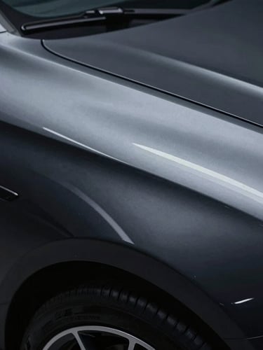 Sleek automotive photography of a high-gloss black fender panel, cool studio LED lighting reflecting a sharp white line, close-up macro lens.