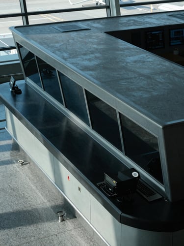 High-angle architectural shot of an airport terminal control room, cool daylight, sharp technical details, blue and slate gray tones, high contrast, 35mm