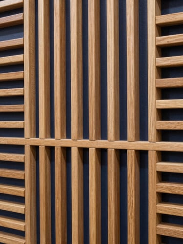 Close-up architectural photograph of perfectly aligned acoustic slat wood panels on a boardroom wall, highlighting clean joints and warm wood tones against deep navy shadows.