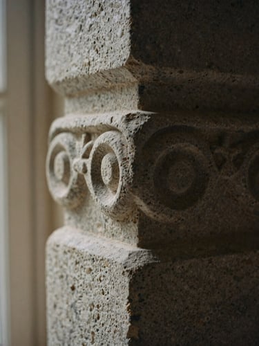 Macro close-up of a carved limestone pillar in soft morning window light, deep shadows, textured stone surface, 35mm film style