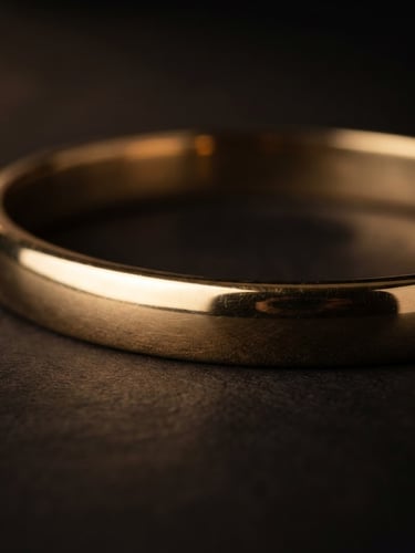 Macro studio photograph of a solid 22-karat gold bangle, deep shadows, soft gold reflections, shallow depth of field, premium luxury aesthetic