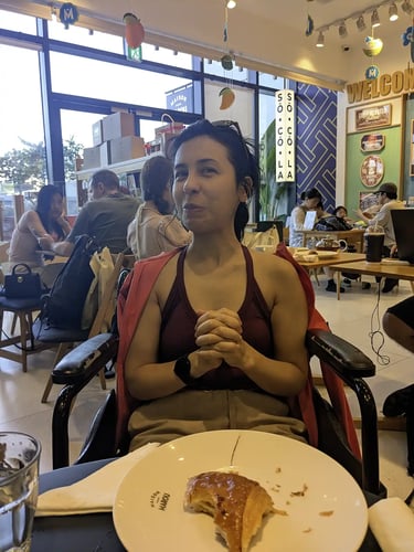 Person sitting in wheelchair at cafe inside Lotte Mall West Lake Hanoi in Hanoi Vietnam