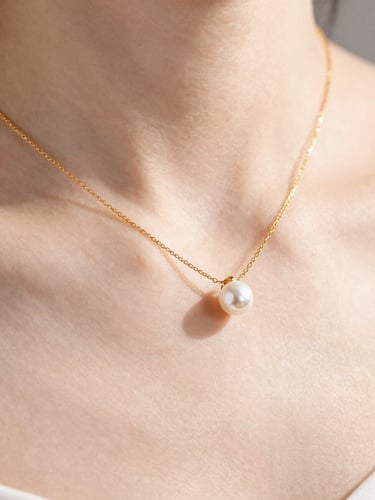 Macro product shot of a delicate gold necklace reflecting soft morning light on elegant collarbone skin, minimalist editorial style