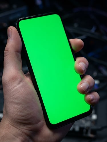 Macro studio shot of a hand holding a modern bezel-less Android phone, vibrant green screen glow casting onto fingers, dark technical background