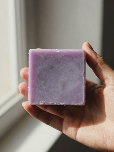 Close-up of a hand holding a solid lavender and coconut shampoo bar, soft CDMX afternoon sunlight, warm editorial photography, 35mm film