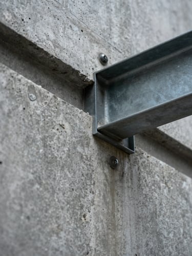Macro close-up of raw textured concrete wall meeting a sharp steel beam, high-contrast architectural lighting, cool daylight.