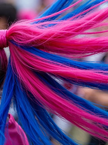 Dynamic close-up of vibrant Kanekalon ponytails in motion, rich saturated pinks and deep blues, sharp detail, 35mm lens