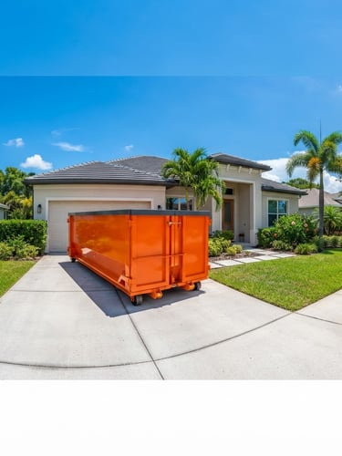 Wide panoramic shot of a clean, branded safety-orange roll-off dumpster neatly placed on a suburban driveway, bright direct Florida sunlight, crisp shadows, green lawn, modern house in the background. Low horizon.