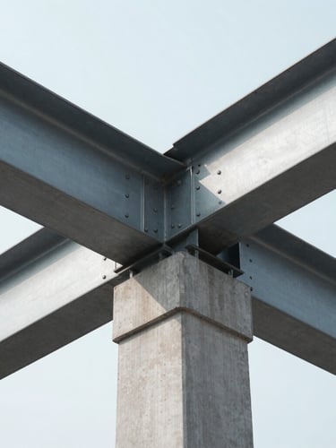 A clean, high-contrast architectural close-up of steel beams and concrete joints meeting at precise geometric angles under crisp, cool daylight.