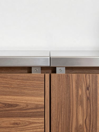 Straight-on eye-level architectural shot of a precision-engineered aluminum kitchen cabinet joint, brushed metallic silver finish meeting warm walnut wood paneling, bright natural daylight, clean metallic and wood textures, sharp focus, 35mm lens