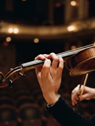 Close-up of a young violinist's hands in focused practice, warm concert hall stage lighting, rich deep tones, shallow depth of field, 35mm