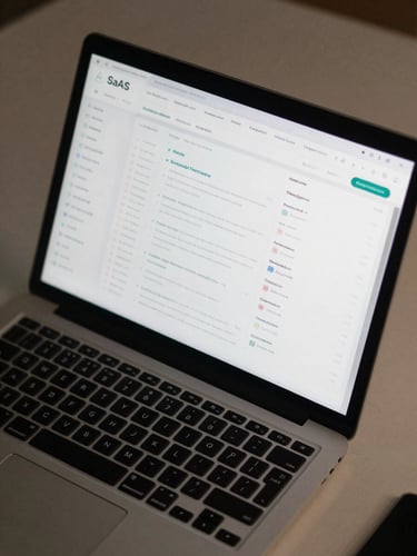 Close overhead shot of a laptop screen displaying a clean SaaS dashboard interface, dark UI with data metrics visible, desk surface partially in frame, neutral studio light, no people
