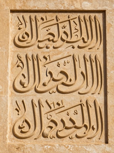 Elegant close-up of classical Arabic calligraphy carved in warm-toned stone, soft side lighting, focusing on geometric symmetry, no people.