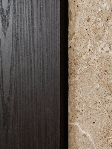 Close-up of premium textured materials, dark oak panels and natural stone in a modern Frankfurt villa, soft side-lighting.