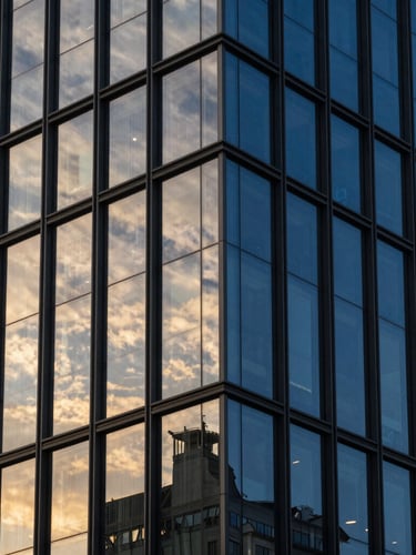 Sleek modern architectural high-rise facade, dramatic golden hour reflections, deep obsidian and royal blue tones, sharp focus, 35mm