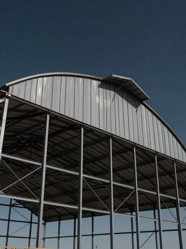 Low-angle architectural shot of a massive engineered steel barn frame rising against a dramatic Texas sky, high contrast navy and charcoal tones, sharp daylight