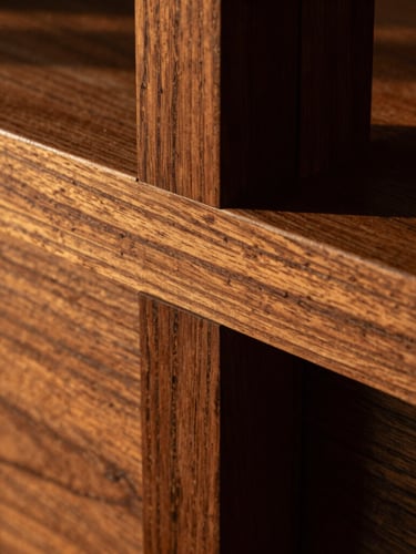 Extreme macro detail shot of flawless mortise-and-tenon joinery, rich dark walnut wood grain with deep shadows and warm golden sidelight