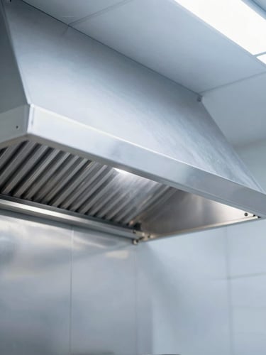 Spotless commercial kitchen hood after professional degreasing, clean stainless steel surfaces, bright white commercial lighting, sharp focus, 35mm