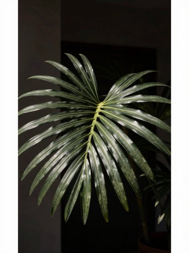 Close-up of artificial palm leaf textures with realistic matte veins, dramatic side-lighting, dark architectural background, vertical portrait crop