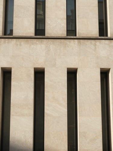 A close-up architectural detail of a modern limestone facade in London, sharp shadows, warm late-afternoon sun