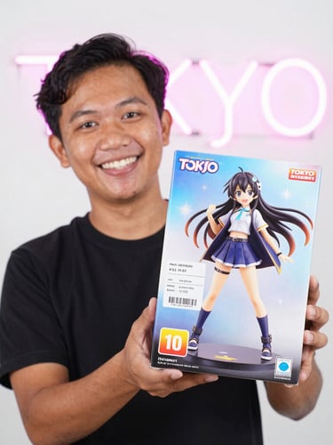 Bright high-key product photography of a happy Indonesian fan holding an unopened official anime figure box with a shipping label from Tokyo, subtle neon pink backlighting.