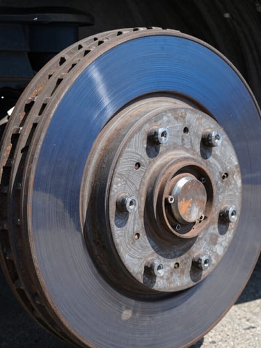 Macro shot of a clean heavy-duty truck brake drum and suspension system, sharp industrial focus, high-contrast daylight, 35mm