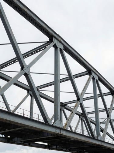 Wide cinematic angle of a weathered steel bridge truss under an overcast industrial sky, sharp focus on structural rivets and texture, high-contrast natural light.