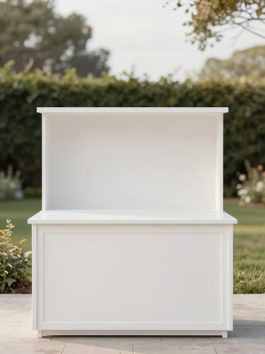 A sleek, minimalist white food station setup at an elegant outdoor garden party, soft natural afternoon light, clean negative space.