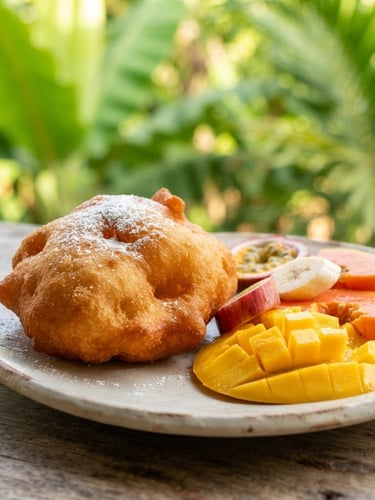 Close-up macro shot of a fresh golden Gabonese beignet and sliced tropical fruits on a clean plate, bright natural morning light, vibrant green leaves in the soft-focus background, 35mm