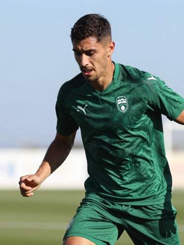 A sharp action shot of a soccer player training under the Mediterranean sun, deep forest green jersey, bright natural light with high-contrast shadows, 35mm lens.