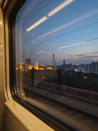 Wide view through a train window at dusk, city lights of Shanghai beginning to glow on the horizon, the window frame cutting the left edge, motion blur on passing tracks below, warm amber light bleeding into deep blue sky