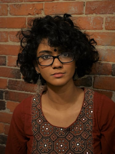 An Image of Athira in front of a brick wall