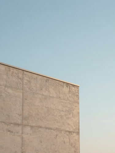 Minimalist architectural detail of a concrete wall meeting a clear sky, soft morning daylight, high negative space, clean lines.