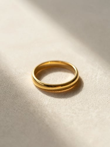Macro flat-lay of a tarnish-resistant gold ring resting on textured linen, soft golden-hour shadows.