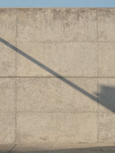 Minimalist architectural detail of a concrete wall in Manhattan Beach under soft morning light, casting clean diagonal shadows, expansive composition.