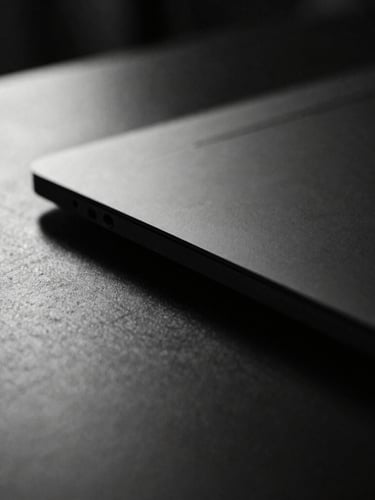 Close-up of sleek hardware on a dark minimalist desk, dramatic key light, high-contrast monochrome, sharp focus