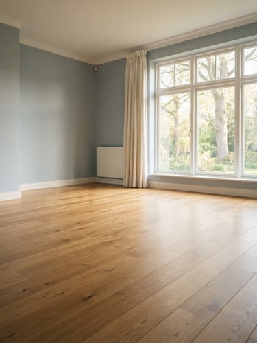 A beautifully cleared, clean, and swept living room with sunlight streaming through a large window, empty wooden floor, calm and respectful atmosphere