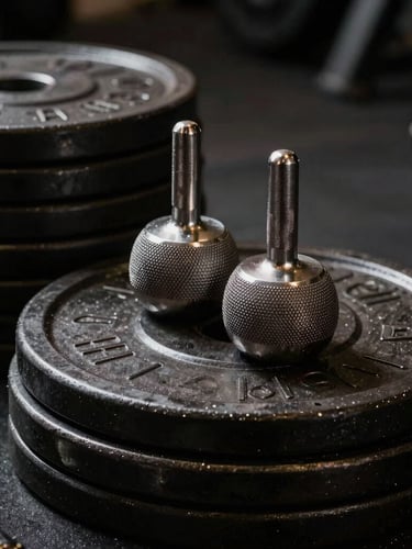 Close-up of premium knurled steel barbells and heavy-duty plates stacked neatly, dramatic key lighting highlighting metallic textures and deep shadows, 35mm lens.