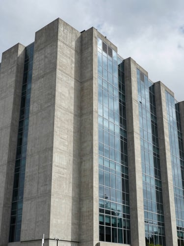 High-contrast architectural shadows on a massive concrete and glass data center facade, overcast sky